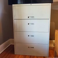 Front view of white lateral file cabinet with four drawers.