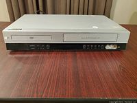 Front view showing DVD tray, VCR slot, control buttons, and AV connectors on the right