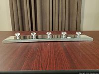 Side angle view of the mirrored clothing hook with five crystal-like hooks, showing the thickness and material of the base and hooks.