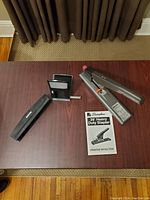 Photo showing Swingline 39 Heavy Duty Stapler, staple remover, hole punch, smaller stapler, and operating instructions on a wooden table.