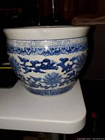 Side view of the vintage blue and white planter showing floral and geometric patterns