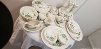 View showing the entire Alton porcelain set including plates, bowls, teacups, candle holders, and fabric.