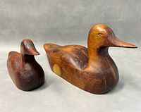 Two wooden duck decoy carvings placed side by side showing their size and condition