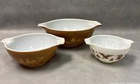 3 vintage Pyrex Cinderella mixing bowls with Early American Heritage pattern shown from front on neutral background.