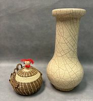 Photo showing both the pottery vase and the woven rooster basket side by side on grey background.