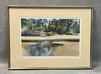 Framed print showing entire artwork with frame and matting. Reflects a calm landscape scene with water and trees.