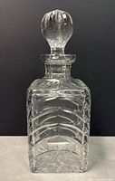 Front view of the clear cut crystal decanter with stopper against black background