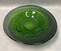 Angled side view showing the bowl's shape, footed base, and textured green interior glass with smooth outer rim.