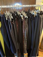 Front view of rack displaying assorted pants and skirts hung on hangers