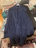 Navy ribbed long coat by Izod Sleepwear draped on hanger