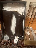 Sergio Rossi brown leather knee boots and Giorgio Armani beige ankle-strap platform shoes in boxes.