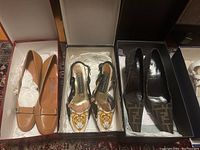 Three pairs of shoes in original boxes displayed side by side