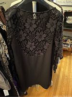 Black short-sleeve A-line dress with floral lace overlay on front yoke