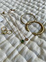 Overall photo of rings, necklaces, and bracelets placed on a quilted fabric surface.