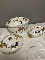 Three covered casseroles arranged on tablecloth