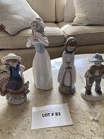 Four figurines arranged on marble tabletop, showing whole set and relative sizes