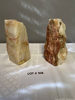 Pair of onyx bookends standing upright on a table, showing side and textured surfaces with natural stone variations.