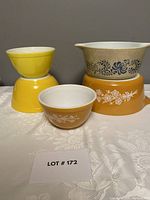 Lot showing all five Pyrex pieces including the Butterfly Gold base and Homestead casserole on top.