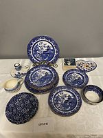 Full lot including blue and white Willow pattern Burleighware plates with gold trims, blue Calico floral plates, Delft candle holder, coasters