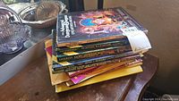 Overview of stack of AD&D books and loose worksheets on table