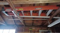 Image shows the full layout of the 5-foot ladder suspended horizontally, revealing orange side rails and silver rungs.