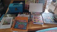 Image showing a table with several quilting and craft books along with a blue plastic case likely holding stamps.