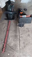 Craftsman 22-inch hedge trimmer and Remington 3.5 HP chainsaw side by side on the floor.
