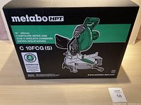 Front of box showing Metabo HPT branding and illustration of compound miter saw; model C10FCG(S)
