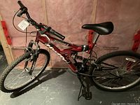 Full side view of red Tindra mountain bike with visible 21-speed labeling and dual shocks.
