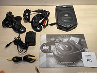 Overview showing console, two controllers, AC adapter, composite AV cable, and user guide.