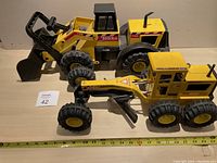 Photo showing both Tonka construction toys side by side with measuring tape indicating length, good overall condition
