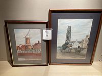 Both framed paintings shown side by side, windmill and church tower scenes