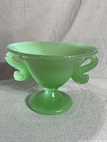 Front angle view of green jadeite compote bowl showing koi fish handles and pedestal base