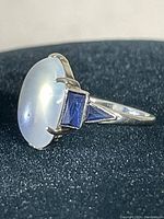 Side profile showing oval cabochon and blue trapezoid accent