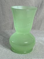 Front view of the vintage mini jadeite vase showing its shape and green color.