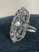 Front view showing the detailed filigree work and central clear stone of the ring