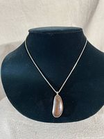 Full view of the silver chain necklace with the brown flake stone pendant displayed on a black jewelry bust.