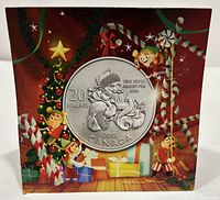 Front view of festive packaging showing the coin design of Santa Claus carrying gifts with Christmas-themed illustrations around