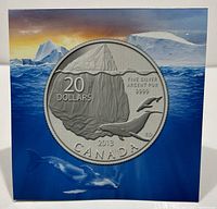 Front view of the coin's packaging showing the iceberg and whale design against a blue and orange sky background.