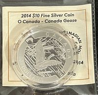 Close-up photo of the 2014 Canada $10 Fine Silver Coin featuring a Canada Goose design, sealed in original packaging with certificate visible in background.