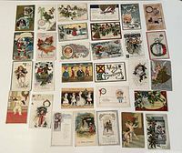 Full display of 30 assorted antique Christmas postcards laid out showing a variety of designs including children, holly, bells, and festive scenes.