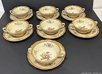 Front view of entire set showing 9 soup bowls and 9 matching saucers arranged in 3 rows of 3 on dark background