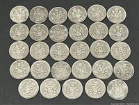 29 Canadian half dollar coins arranged on a black surface showing the reverse side with the Canadian coat of arms.