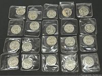 Overview of 23 silver-colored Toronto Blue Jays collectible coins, each in individual plastic holders, arranged in rows on a dark background.