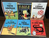 Full set of 6 Tintin books arranged flat, showing front covers and titles in French.