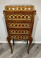 Front view of entire jewelry chest showing serpentine form, marquetry and cabriole legs