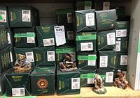 Shelf filled with numerous green Boyd's Bears & Friends boxes, and four display figures on top of the boxes showing different bear characters.