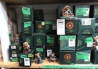 Shelf with stacked green boxes and some Bear figurines visible in front and on top of boxes with handwritten notes on boxes identifying characters.