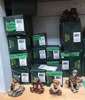Boxes with labeled green Boyd's Bears collectible packaging and figurines displayed in front, showing multiple boxed items and four unpacked figures.