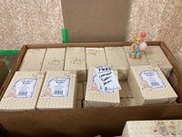 Box containing 28 Cherished Teddies boxed figurines and one figurine displayed outside the boxes, showing size and packaging.